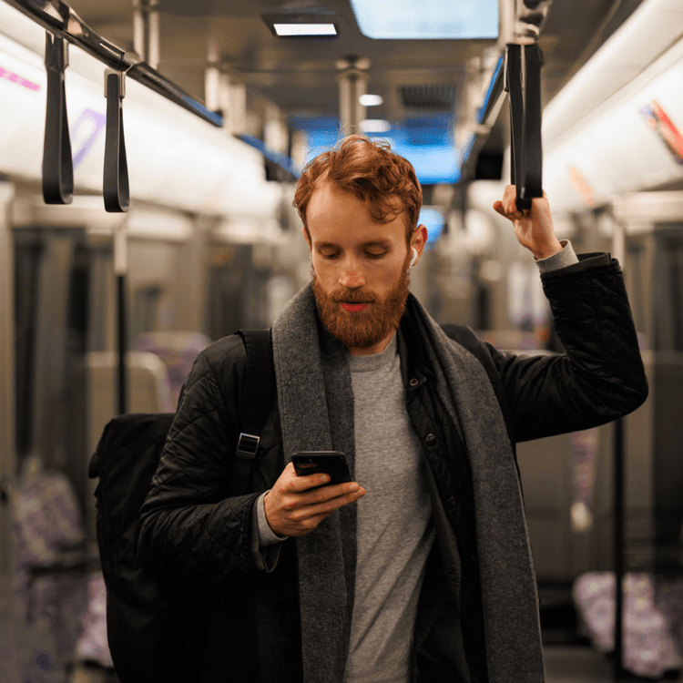A man on the train looking at his mobile phone
