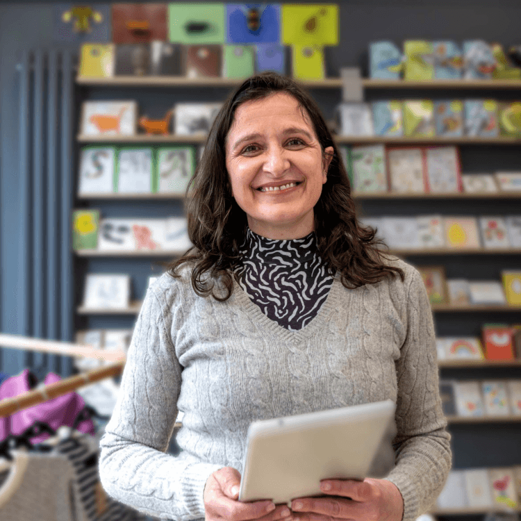 Woman standing in a shop holding a tablet