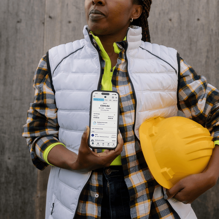Woman construction worker holding up the Zempler Bank App