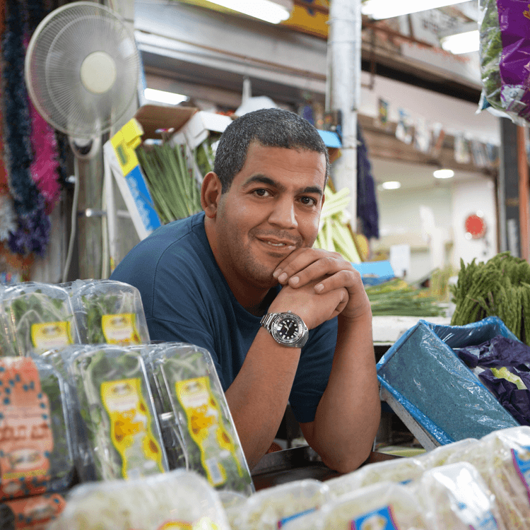 A man standing at a vegetable stall