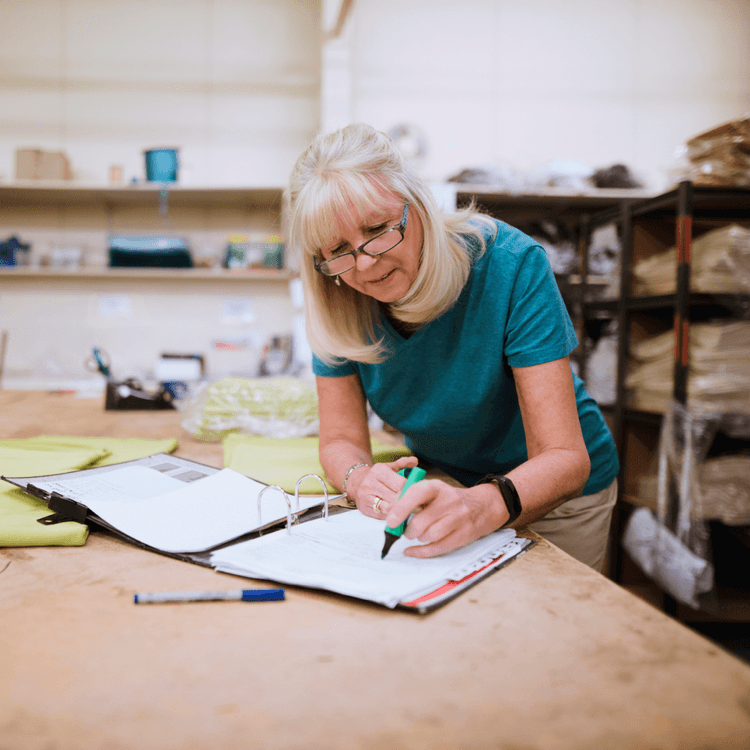 A woman highlighting some forms in an office